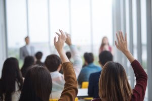 Students raising their hands in class