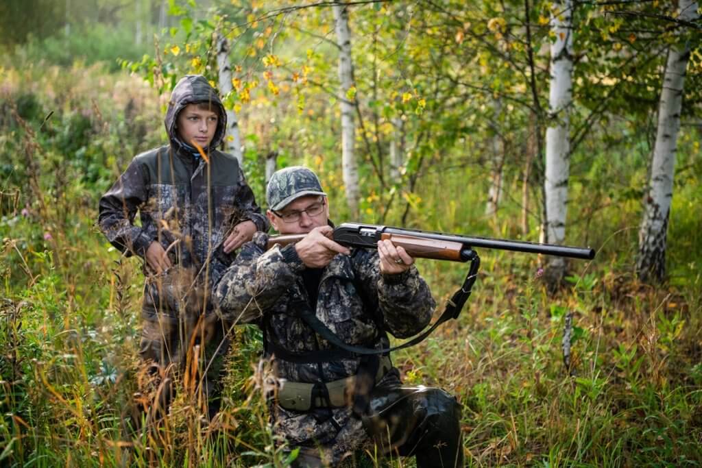 A ranger teaching his son how to spot game in the wild