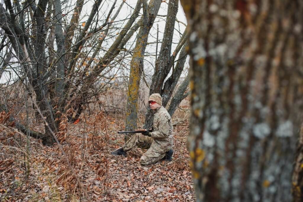 A hunter in the wild aiming with his rifle